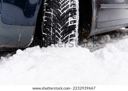 Off road winter tire packed with snow in deep snow.Detail of car tires in winter on the road covered with snow.Car tires on winter road covered with snow. Vehicle on snowy morning at snowfall.