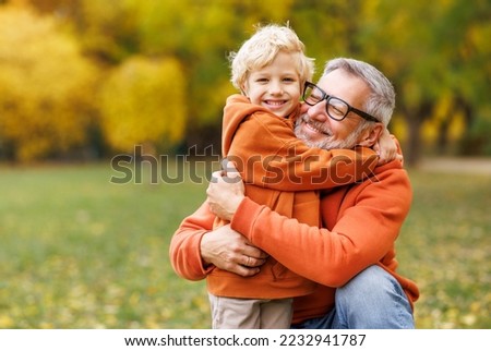 happy family ыьшдштп grandfather and grandson hug on  autumn walk in park Royalty-Free Stock Photo #2232941787