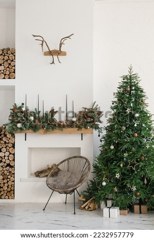 Stylish Scandinavian minimalistic Christmas interior with fireplace and Christmas tree. Cozy house. Modern interior of a country house with firewood Royalty-Free Stock Photo #2232957779