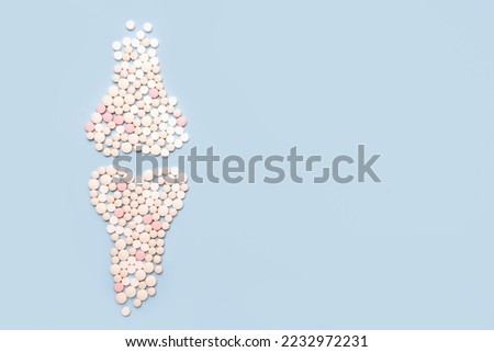 World osteoporosis day. Human  joints and bone made of pills on blue background Royalty-Free Stock Photo #2232972231