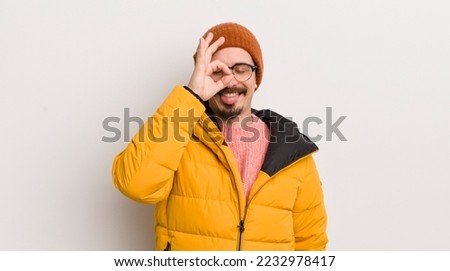 young handsome man with a coat against white wall