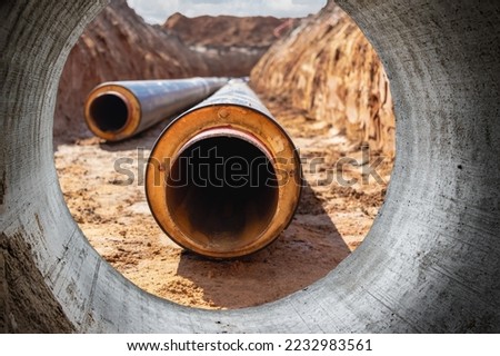 Laying of high pressure pipes for hot water supply. Underground pipeline works. Heating. Insulated pipes in a trench. Water supply at home. View from the big pipe