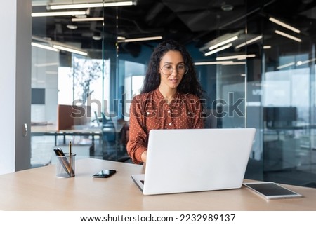 Cheerful and successful indian woman programmer at work inside modern office, tech support worker with laptop typing on keyboard smiling. Royalty-Free Stock Photo #2232989137