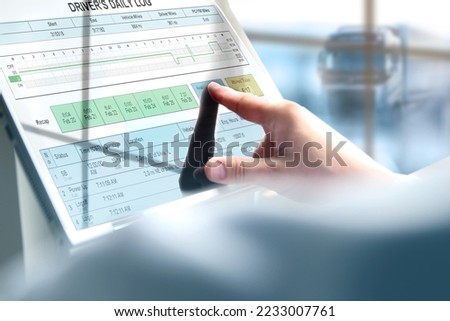 Safety manager is showing to Truck driver  th  electronic logbooks on a tablet Royalty-Free Stock Photo #2233007761