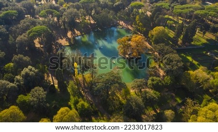 Aerial view of the small lake in Villa Borghese park. This pond is located in Rome, Italy. There are small row boats with people.