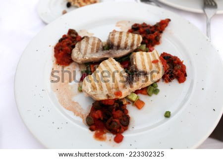 Grilled fillet of swordfish on a white plate