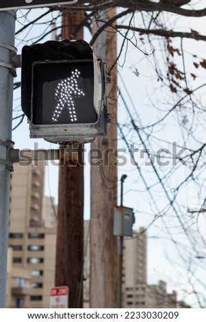 Closeup to a traffic light with the pedestrian signal on.