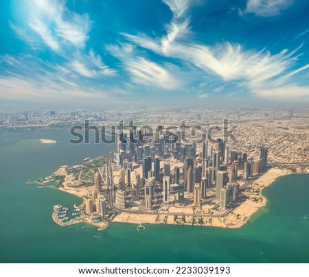 Aerial view of Doha skyline from airplane. Modern skyscrapers at sunset, Qatar. Royalty-Free Stock Photo #2233039193
