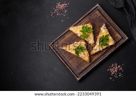 Tasty sandwich with crunchy toast with egg and cheese. Drinking breakfast on a dark concrete background