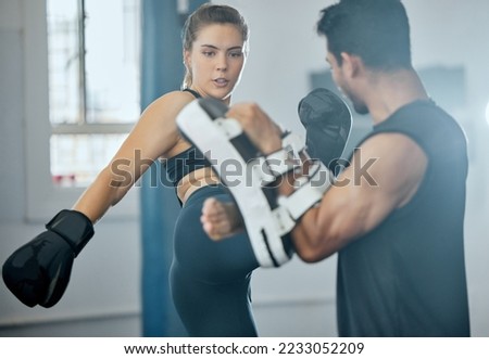 Kick boxing, training and fitness woman with trainer exercising, doing self defense workout or fitness activity in a wellness gym. Determined, strong and athletic people in a sports or exercise class Royalty-Free Stock Photo #2233052209