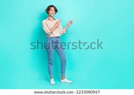 Full length photo of adorable optimistic girl two arm direct empty space visit boutique stylish clothes isolated on cyan color background
