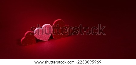 Valentine's day concept banner with sparkling glitter hearts against abstract red background and the bokeh of garland with space for text. Festive St. Valentine's day Background.