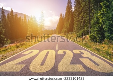 Empty asphalt road and New year 2023 concept. Driving on an empty road in the mountains to upcoming 2023. Concept for success and passing time.