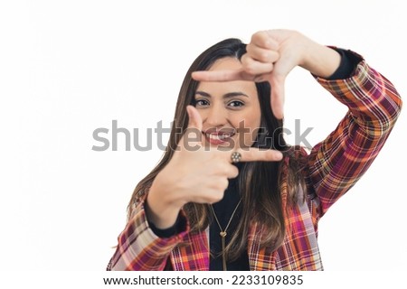 Portrait of young brunette smiling woman shaping a square with her fingers. High quality photo