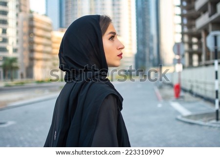 Side view portrait of beautiful Arab young woman wearing traditional arabic clothing. Royalty-Free Stock Photo #2233109907