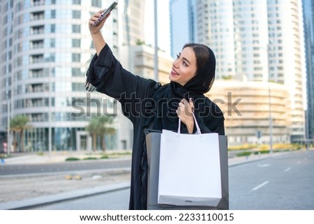 Young beautiful Arabian middle eastern woman taking selfie with mobile phone on the city street.