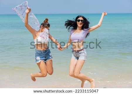Two girlfriends hugging up and enjoying on the sea beach. A pair of girls in love cuddling on a tropical beach. romantic young lesbian couples in love and walking together on the beach.Concept of LGBT