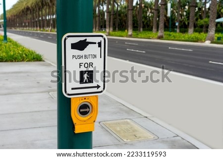 Push Button For Crossing sign on a green post