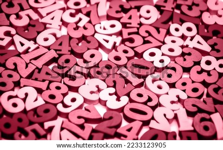 Black and white background of wooden numbers from zero to nine. Abstract texture with numbers. Concept: back to school, arithmetic, learning to count. Color of the Year 2023 Viva Magenta 18-1750 TCX