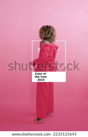 Color Pantone 2023 Viva Magenta color. New trend color. One wall. African American woman in color of the year costume on a plain background in the studio