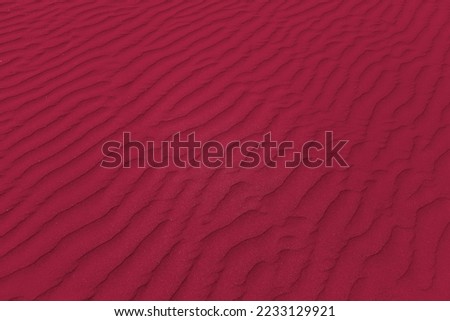 closeup of sand pattern of a beach in the summer. New 2023 trending PANTONE 18-1750 Viva Magenta color

