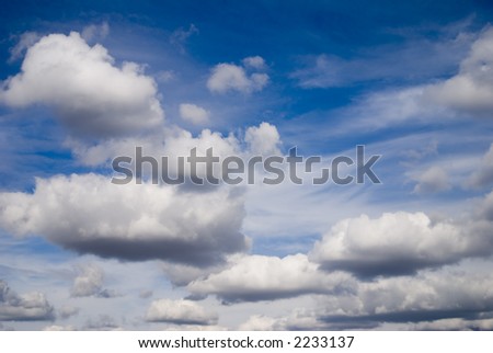 Banks of cumulus clouds against a bright blue sky.