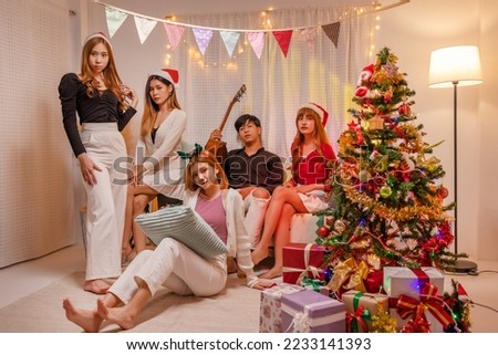 Happy young Asian friends celebrate Christmas and new year party together at home.