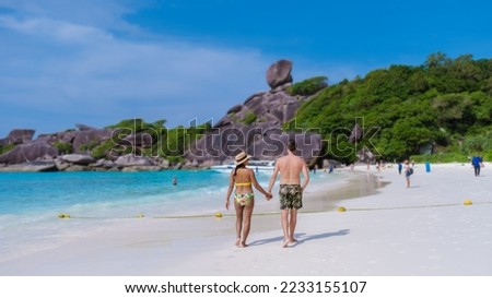 A couple of men and women on a trip to the tropical Island with white beach Similan Islands Thailand. 