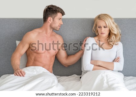 Not in Good Terms Young Couple on Bed with White Cover with Gray Wall Background.
