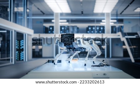 Mobile Robot Dog Standing in a High Tech Modern Industrial Facility. Robot Prototype with a Screen with Running Software Code. Royalty-Free Stock Photo #2233202613