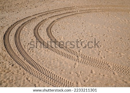 car tire footprint and wheel track on sand in desert beach on fine sand of desert dune Royalty-Free Stock Photo #2233211301