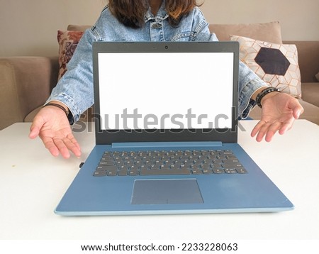 mockup laptop. asian woman showing new model laptop to recommend buying advice in casual jean jacket on white table