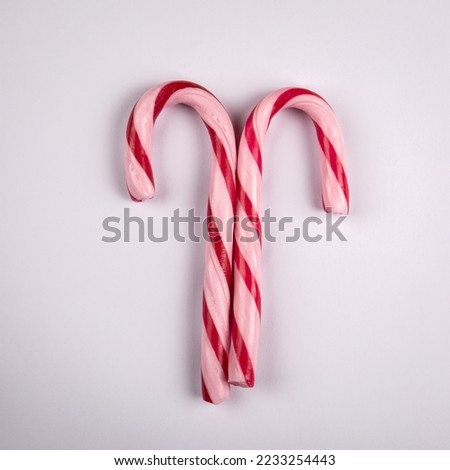 Two red candy canes on a white background.