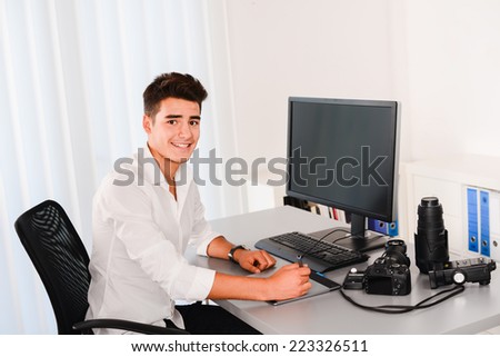 handsome young man editing photography with graphic tablet on computer