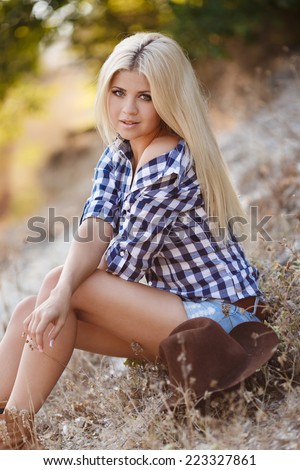 Young american cowgirl woman portrait outdoors. Beautiful natural woman saying hello looking at camera. girl in her twenties outdoor in nature.