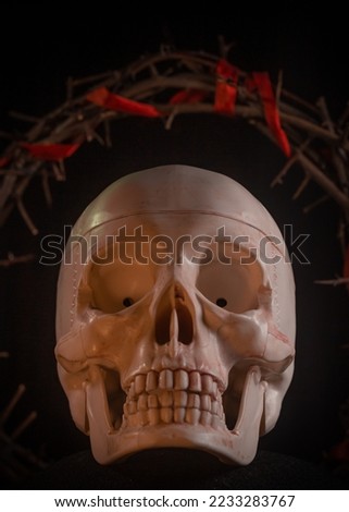 Skull of a person with crown of thorns close up on a black background