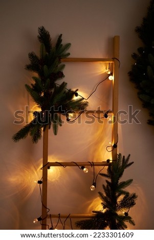 New Year's wooden ladder with yellow garlands. Vertical photo. Can be used as a background. New Year's mood.