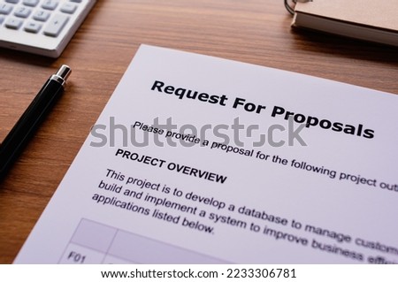 There is dummy documents that created for the photo shoot on the desk about Request For Proposal.