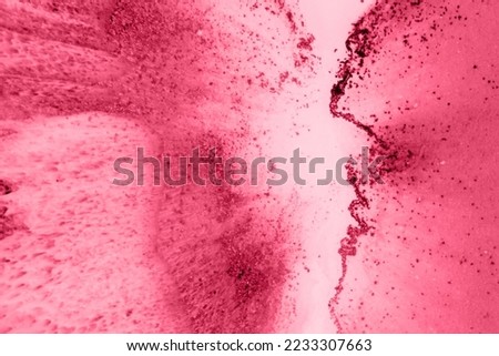 Spread-out acrylic paint. Abstract background, made in the technique of fluid art. Image toned in trendy pantone color of year 2023 Viva Magenta