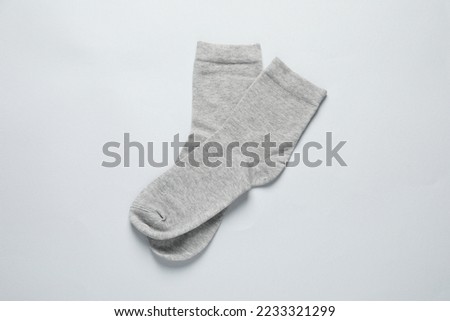 Pair of grey socks on light background, flat lay