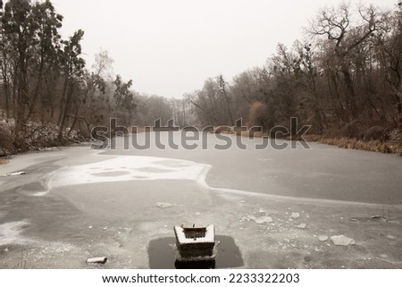 building for water release on the lake covered with ice, winter water landscape