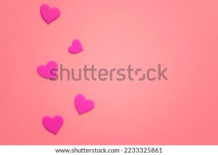 Lovely magenta hearts on pink paper table. Copy space