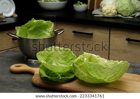 Fresh Savoy cabbage leaves on black table in kitchen Royalty-Free Stock Photo #2233341761