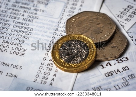British shopping receipt with coin change over it in england uk. Royalty-Free Stock Photo #2233348011