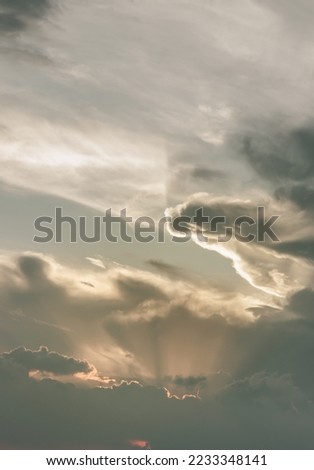 The sun's rays passing through the clouds and shining form an interesting light pattern against the sky. Space for text, Selective focus.