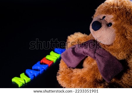Maxima's name on a black background and a teddy bear.