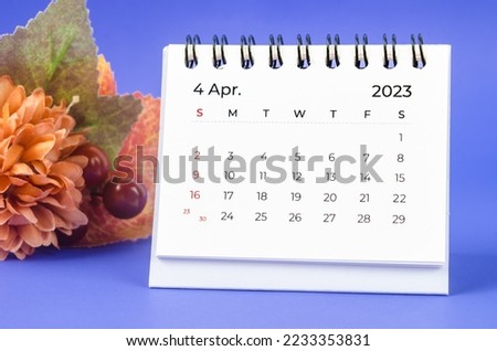 April 2023 Monthly desk calendar for 2023 year with flower on purple background. Royalty-Free Stock Photo #2233353831
