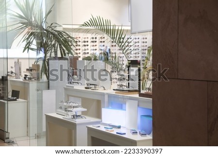 Showcase with different glasses in optical store Royalty-Free Stock Photo #2233390397