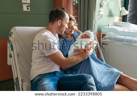 A Mother and father with her newborn baby at the hospital a day after a natural birth labor Royalty-Free Stock Photo #2233398805