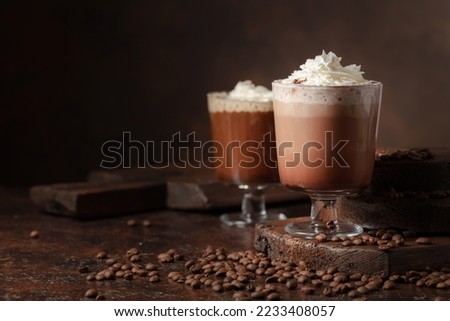Coffee and chocolate drinks with whipped cream on a brown background. Cpoy space.